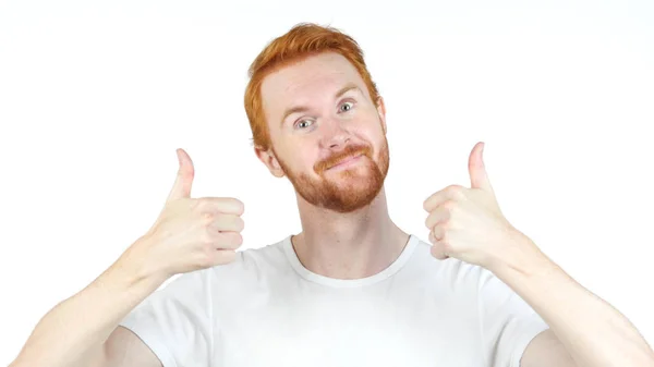 Alegre vermelho cabelo homem polegares até posando e sorrindo para a câmera, branco fundo — Fotografia de Stock