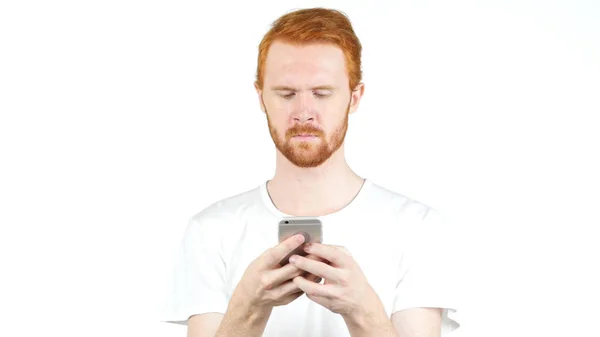 Rood haar man met mobiele slimme telefoon, te typen bericht op witte achtergrond — Stockfoto