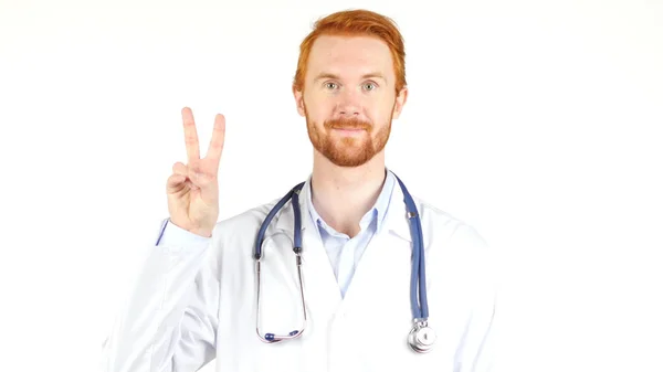 Portrait of  doctor showing victory sign against white background — Stock Photo, Image