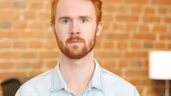 Портрет молодого человека с рыжими волосами, офис в лофте — стоковое фото