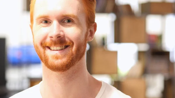 Gros plan portrait de jeune homme barbe aux cheveux rouges heureux souriant à la caméra — Photo