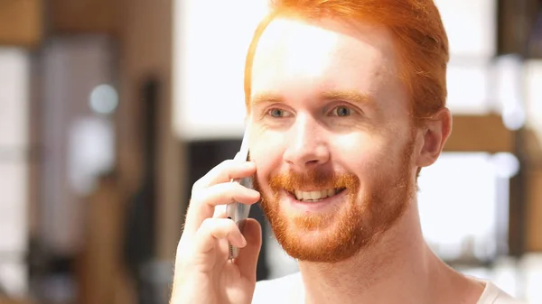 Positivo vermelho cabelo barba homem falando no telefone inteligente — Fotografia de Stock