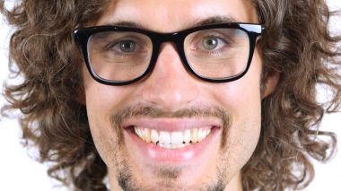 Gülümseyen adam yüz, yakın çekim, kıvırcık saçlar