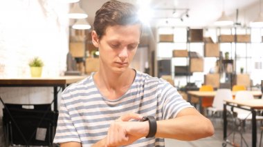 Smartwatch kullanan genç adamın portresi,
