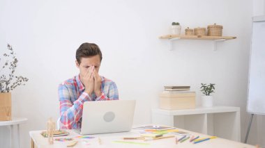 Genç yaratıcı tasarımcı adam yaratıcı ofisinde çalışan baş ağrısı ile