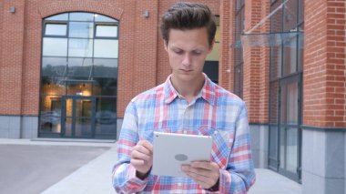 Genç adam, öğrenci, tablet bilgisayar, yürüyüş açık kullanarak Tasarımcısı