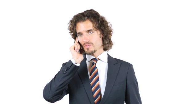 Серьезный бизнесмен разговаривает по мобильному телефону, кудрявые волосы — стоковое фото