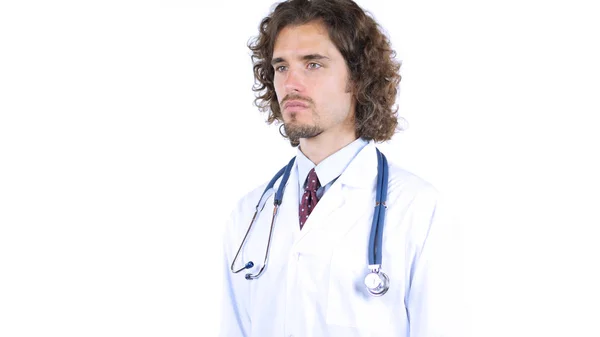 Młody lekarz patrząc na bok, białe tło — Zdjęcie stockowe