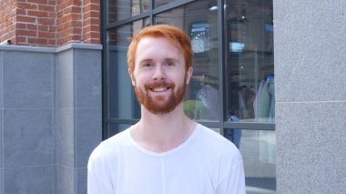 Ofisinin kırmızı tüyler dışında gülümseyen genç adam