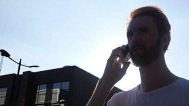 Gün batımı sırasında telefon konuşma, açık, siluet