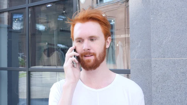 Rozmowy na telefon, z aparatu ruchu wokół młodego człowieka, na zewnątrz, czerwone włosy — Zdjęcie stockowe