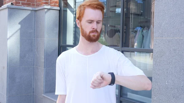 Homme debout attendant et regardant le temps sur la montre-bracelet, en plein air — Photo