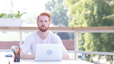 Açık ofis, kırmızı tüyler oturan ciddi adam