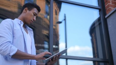 Meşgul çevrimiçi Tablet üzerinde çalışıyorsanız, ayakta genç erkek Tasarımcısı siyah