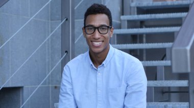 Genç erkek Tasarımcısı merdivenlerde, açık portre oturan siyah