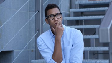 Office dışındaki merdivenlerde oturan düşünceli düşünme genç işadamı