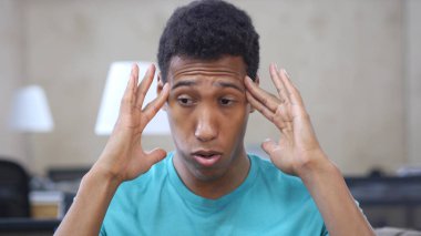 Umutsuz yorgun hayal kırıklığına uğramış genç Afro-Amerikan adamla baş ağrısı