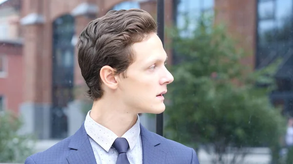 Retrato de un joven empresario mirando a su alrededor, al aire libre —  Fotos de Stock