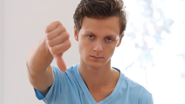 Pouce baissée par un jeune homme, portrait d'intérieur — Photo