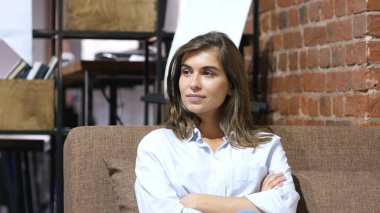 Kameraya bakarak, iş yerinde oturan kız