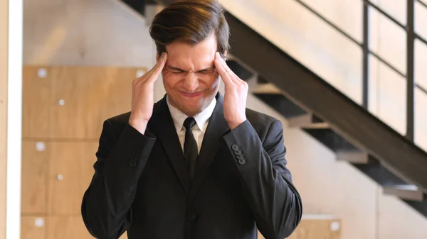 Gespannen jonge Businesman in Office, hoofdpijn — Stockfoto