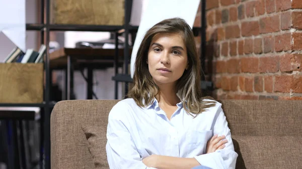 Mädchen sitzt bei der Arbeit und schaut in die Kamera — Stockfoto