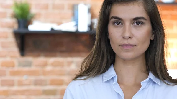 Lateinisches Mädchen schaut in die Kamera, steht in ihrem Loft-Büro — Stockfoto