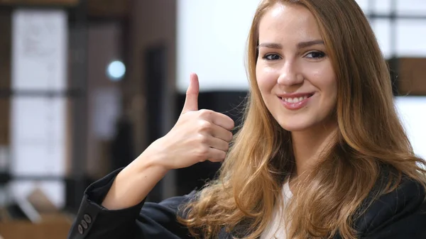 Thumbs Up by Beautiful Girl Sitting Indoor, Portrait — Stock Photo, Image