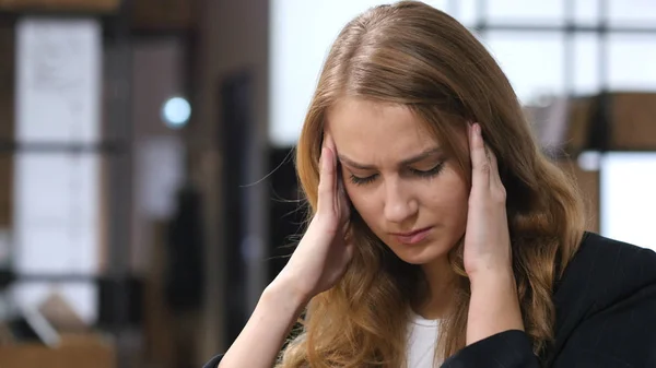 Dolor de cabeza, frustrado, trastornado, chica tensa sentada en interiores — Foto de Stock