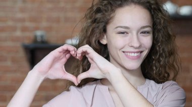 Genç kadın, kapalı el yapımı kalp işareti
