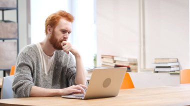 Düşünme ve dizüstü bilgisayarda çalışan dalgın adam