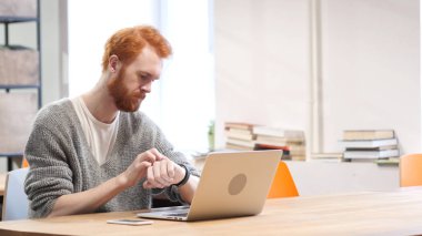 Ofiste iş yerinde smartwatch kullanan adam