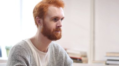 Yaratıcı ofisinde kırmızı tüyler ile ciddi adam