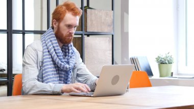 Dizüstü bilgisayar, tasarımcı çalışan erkeğin sakallı