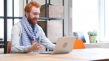 Sakallı adam kutluyor başarı dizüstü bilgisayarda çalışırken