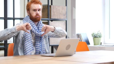 Başparmak aşağı dizüstü bilgisayarda çalışırken adam tarafından