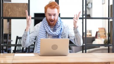 Dizüstü bilgisayarda çalışırken adam kutluyor başarı