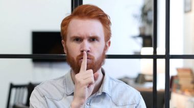 Genç adam, dudaklarında parmak sessizliktir jesti