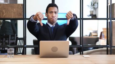 Başparmak aşağı siyah dizüstü bilgisayarda çalışırken işadamı tarafından