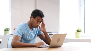 Dizüstü bilgisayarda çalışan adam yorgun genç siyah