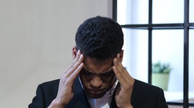 Baş ağrısı, üzgün gergin genç siyah iş adamı
