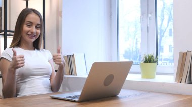 Başparmak yukarıya üstünde Laptop çalışırken genç kız tarafından