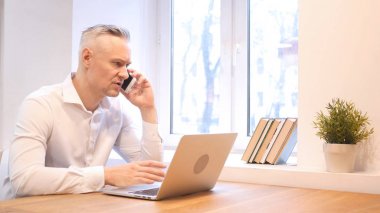 Orta yaş adam tarafından işyerinde iş telefon konuşma