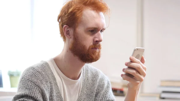 Lezing bericht op Smartphone, Man met rode haren — Stockfoto