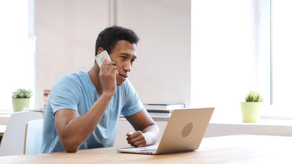 Hablar por teléfono, joven negro en el trabajo —  Fotos de Stock