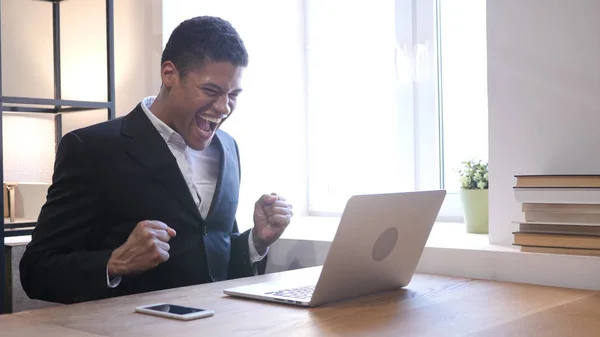 Afro-American affärsman firar framgångar medan du arbetar på Laptop — Stockfoto