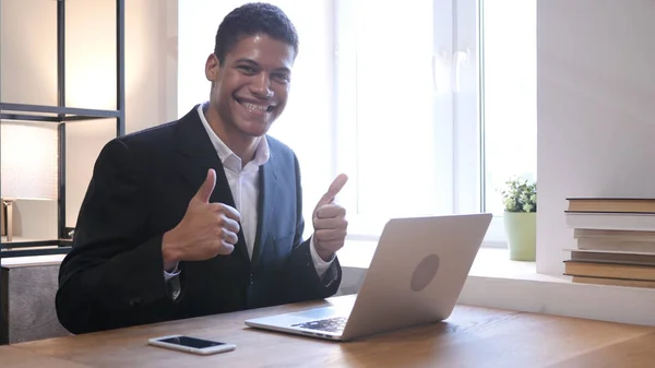 Thumbs Up by Black Businessman while Working on Laptop