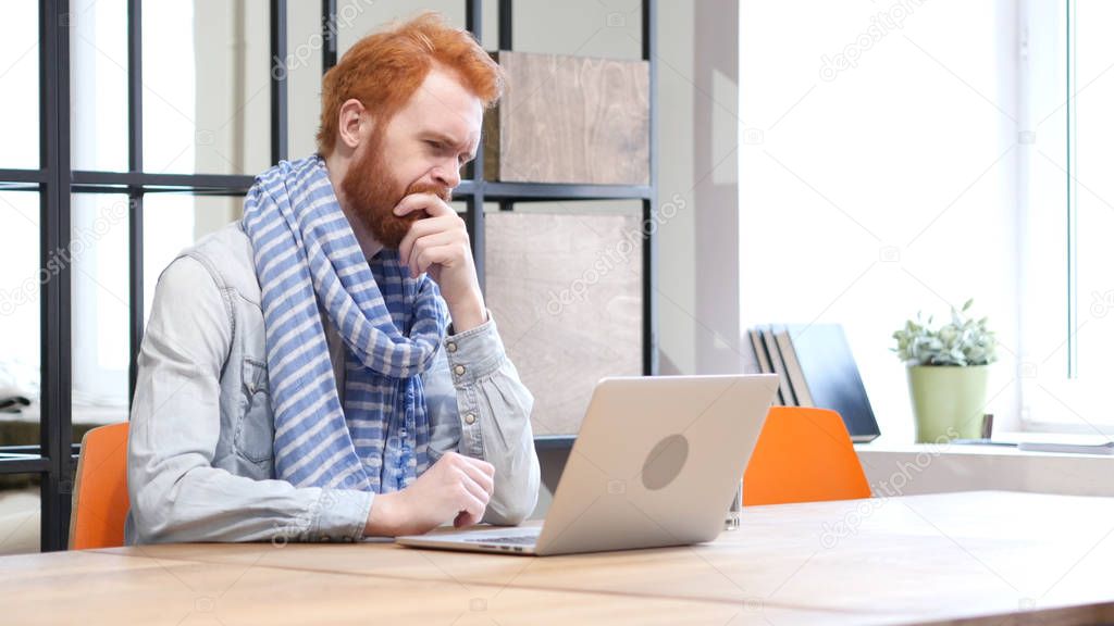 Pensive Man Working on Laptop in Office
