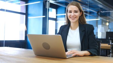 İş yerinde kamera doğru gülümseyen kadın