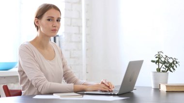 Yaratıcı kadın iş yerinde kamera bakıyor